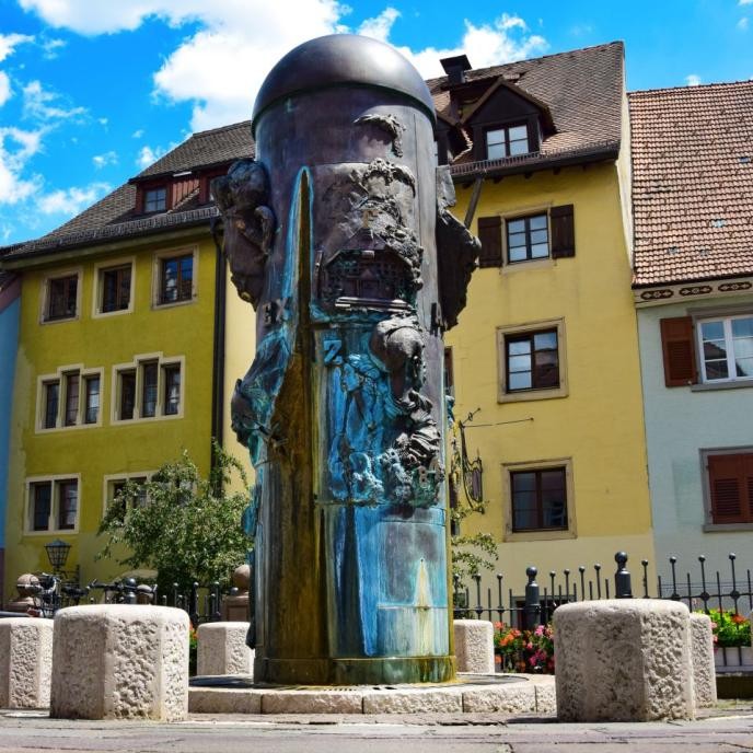 Säule mit realistisch augearbeitenteten Reliefs